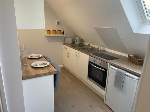 a small kitchen with a sink and a stove at The Annexe - woodland views and close to beach! in Barton on Sea