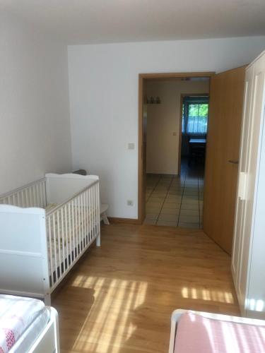 an empty room with a crib and a hallway at Ferienhof Kröger in Bielefeld