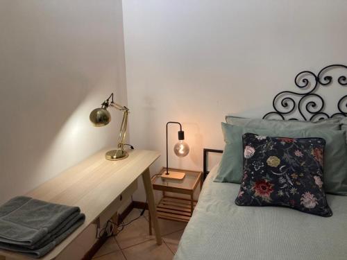 een slaapkamer met een bed, een bureau en een lamp bij Apartment Milan - Città Studi in Milaan