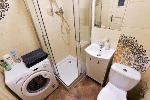 a bathroom with a shower and a toilet and a sink at Grójecka Apartament in Warsaw