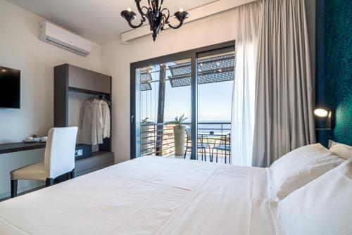 a bedroom with a large white bed and a balcony at Taormina Palace Hotel in Taormina