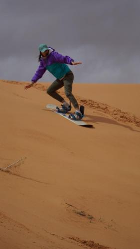 une personne faisant du snowboard dans le désert dans l'établissement Desert Jewel Camp, à Wadi Rum