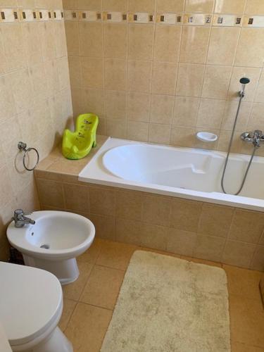 a bathroom with a tub and a toilet and a sink at Dor-Ka Vendégház Makó in Makó