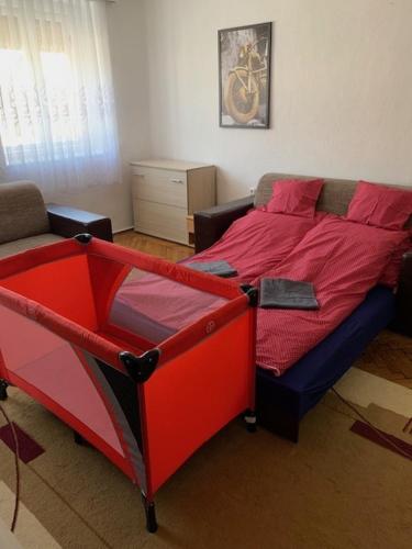 a bedroom with a bed with a red comforter at Dor-Ka Vendégház Makó in Makó