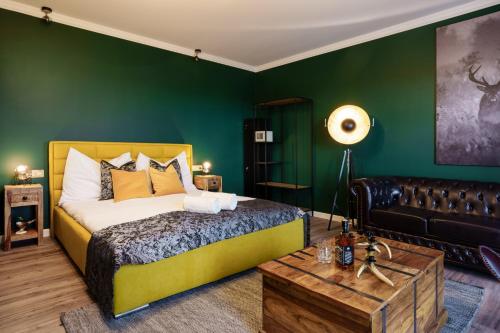 a bedroom with green walls and a bed and a couch at Nagypince Borhotel Wine and Spa in Böhönye