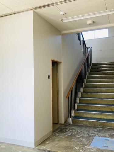 an empty hallway with stairs in a building at Yamagata Guesthouse山形ゲストハウス in Murayama