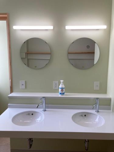 two sinks in a bathroom with two mirrors at Yamagata Guesthouse山形ゲストハウス in Murayama