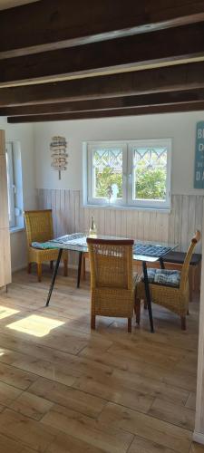jadalnia ze stołem, krzesłami i oknami w obiekcie Büsumer blaue Krabbe w Büsum