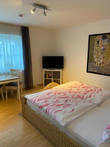 a bedroom with a bed and a table and a television at Ferienhof Kröger in Bielefeld