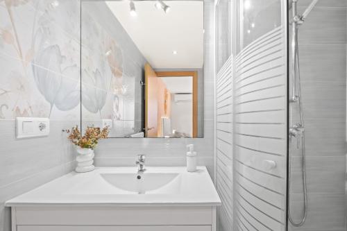 uma casa de banho branca com um lavatório e um chuveiro em Los Ranchos 4-3 Apartment Levante Beach em Benidorm