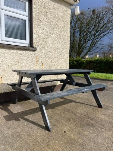 a picnic table sitting in front of a building at Enniscrone - AitEabha Country Cottage in Enniscrone