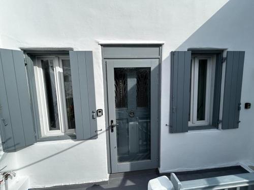 un edificio blanco con dos ventanas y una puerta en Cozy Studio Mykonos Town, en Mykonos ciudad