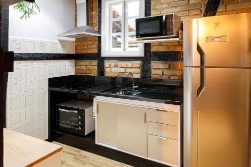 uma cozinha com um frigorífico de aço inoxidável e um micro-ondas em Casa enxaimel em Pomerode em Pomerode