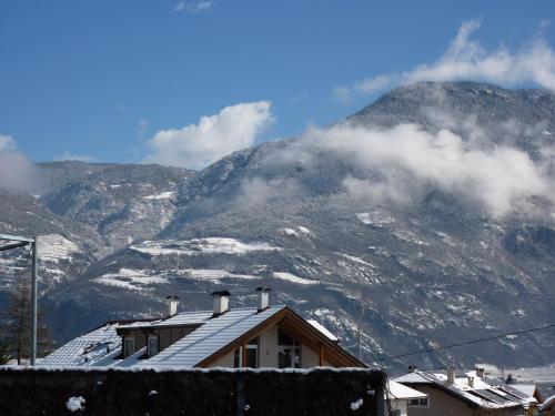 a snow covered mountain with a house in the foreground at Garni Rebhof in Nalles
