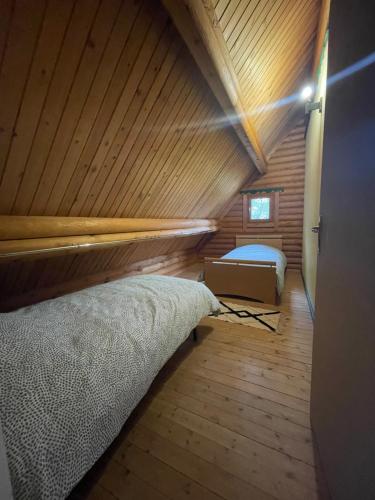 Habitación con cama en una cabaña de madera en Chalet à la campagne, en Hautot-lʼAuvray