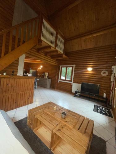 una sala de estar con una mesa de madera en una habitación en Chalet à la campagne, en Hautot-lʼAuvray