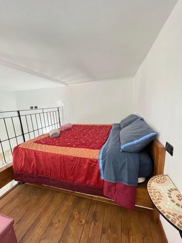 a bedroom with a bed with a red comforter at Honeyapartment in Brindisi