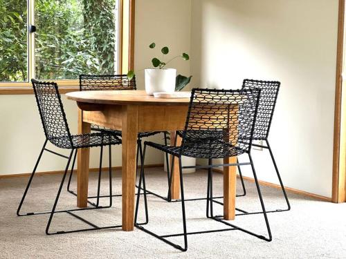 einem Tisch mit vier Stühlen und einer Topfpflanze darauf in der Unterkunft Richmond Cottage in Richmond