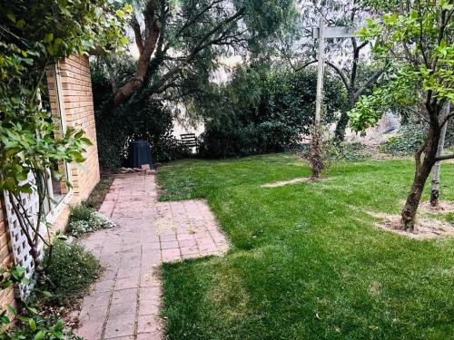 einen Garten mit einem gemauerten Gehweg im Gras in der Unterkunft Richmond Cottage in Richmond