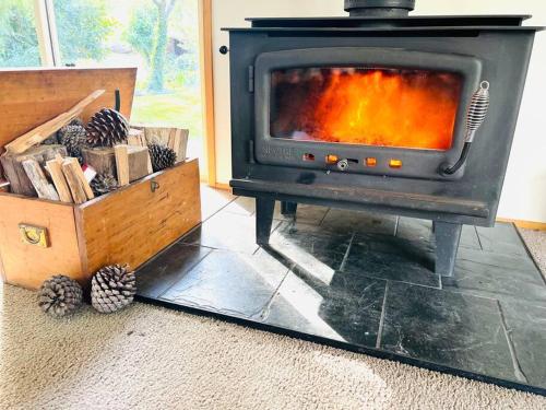 a stove in a living room with a wooden box at Richmond Cottage in Richmond
