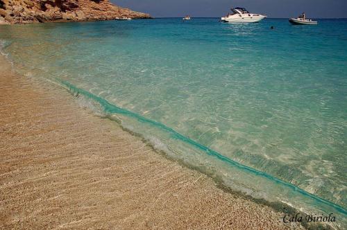 a sandy beach with two boats in the water at Albergo Diffuso Mannois in Orosei