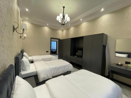 Cette chambre comprend deux lits et un lustre. dans l'établissement VİP COTTAGE, à Qabala