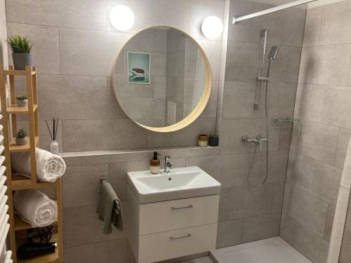 a bathroom with a sink and a shower with a mirror at Forest 57 in Sopron