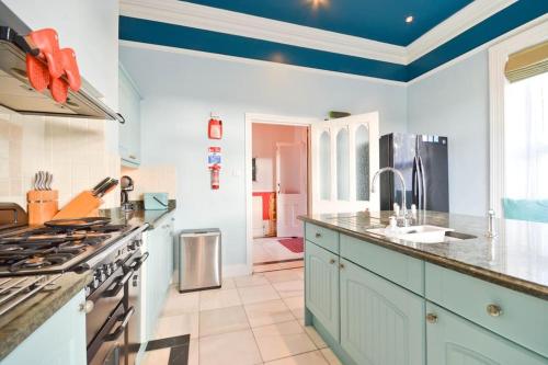 een keuken met witte muren en een blauw plafond bij Clevelands Country House Holiday Rental 10 Guests in Wroxall