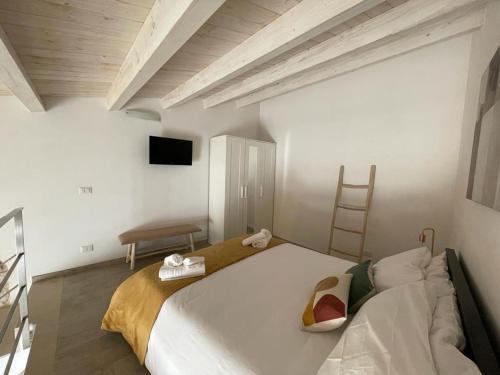 sypialnia z dużym białym łóżkiem i telewizorem w obiekcie Casa Shekelesh w mieście Scicli