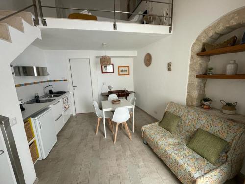 sala de estar con sofá, mesa y cocina en Casa Shekelesh, en Scicli