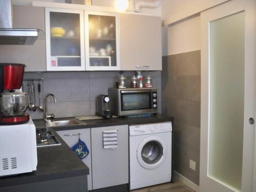 eine Küche mit einer Waschmaschine und einer Mikrowelle in der Unterkunft locazione Mery in Venedig