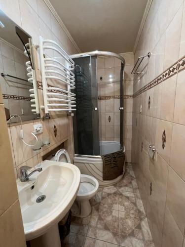 y baño con aseo, lavabo y ducha. en 10 Kotliarska Moisha House, en Leópolis