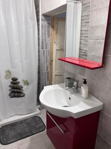 een badkamer met een wastafel, een spiegel en een douche bij La casa dei Nonni in Parabita