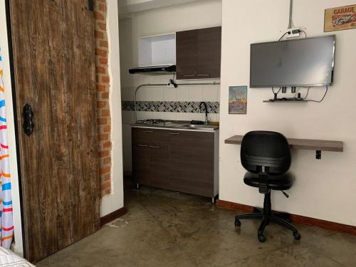 a kitchen with a desk and a chair in a room at La Curva Apartamentos in Cali