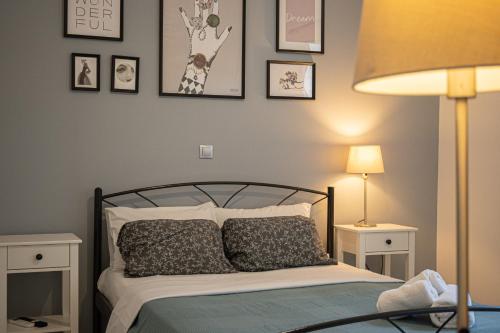 una camera da letto con un letto con immagini appese al muro di Thalia apartments a Kalamáta