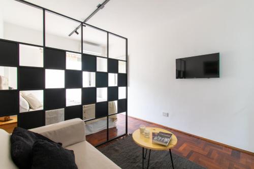 a living room with a black and white checkered wall at Franca Estadías Temporarias in Rosario