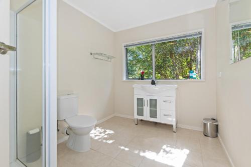 a bathroom with a toilet and a glass shower at Camellia with WiFi - Paihia Unit in Paihia