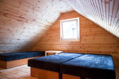 a attic room with a bed and a window at Domki Letniskowe Blue Sky 1 in Rewal