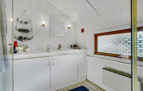 een witte badkamer met een wastafel en een raam bij Awesome Home In Kge With House Sea View in Valløby