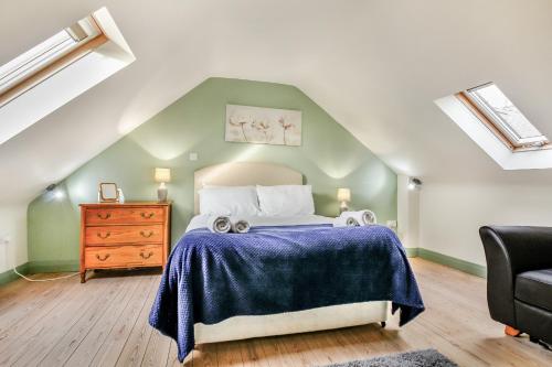 sypialnia z łóżkiem i komodą na poddaszu w obiekcie No 1 The Granary w mieście Llangefni