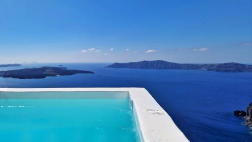 a swimming pool with a view of the ocean at Karpimo Scenery in Firostefani