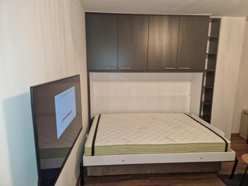 a small bedroom with a bed and cabinets at Extra studio apartment Sarajevo in Sarajevo