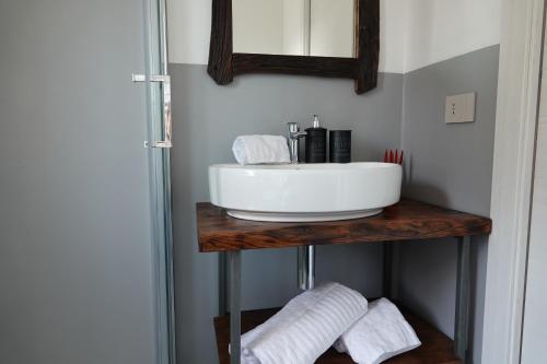 a bathroom with a sink and a mirror and towels at Casale Bella.Vista in Pianello Del Lario
