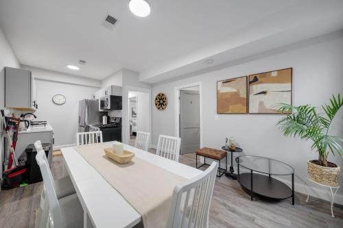 a kitchen and dining room with a white table and chairs at 4BR 1BH Apt in South Boston near Old Harbor Beach Private Rooms in Boston