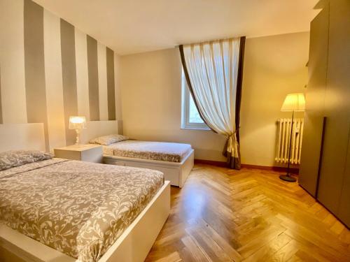 Una habitación de hotel con dos camas y una ventana. en Casa Lagrange - cozy & elegant apt in the hurt of centre, en Turín