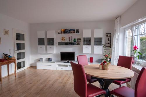 a living room with a table and chairs and a television at FH Ostfriesland to Huus, zw. Emden und Greetsiel in Hinte