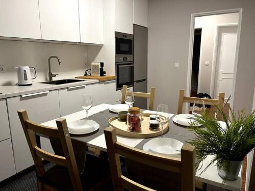 a kitchen with a table and chairs and a kitchen with white cabinets at Olympic Apartment in Braga