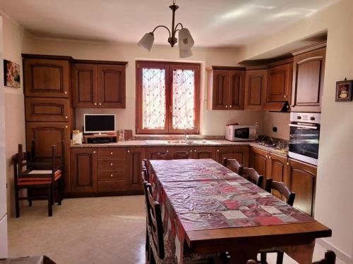 una cocina con armarios de madera y una mesa con sillas. en Immaculate 4-Bed House in Cassino Villa Aurora, en Cassino
