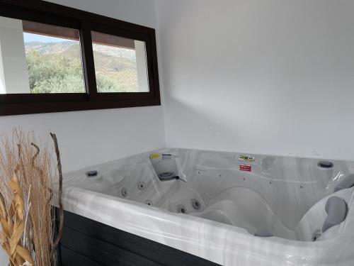 a bath tub in a room with a window at Cortijo Tayula-Centro de Recuperación y Descanso in Granada