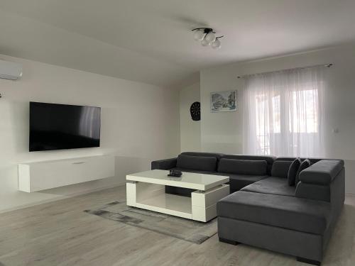 uma sala de estar com um sofá e uma televisão em Apartman Kis em Jajce